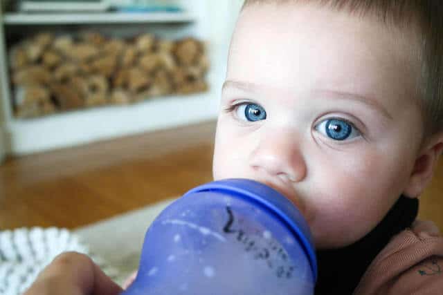 blue eyed baby drinking from bottle